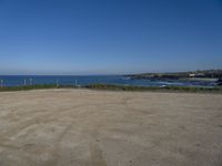 the empty parking lot in front of the beach is a bit empty with a small blue sky and blue water on a sunny day