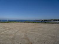 the empty parking lot in front of the beach is a bit empty with a small blue sky and blue water on a sunny day