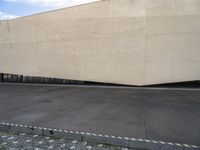 the back of a building with several large white walls on top of it and brick walkways in between them