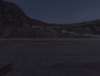 a view of the desert from an overlook with a moon in the sky and a building visible