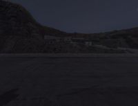 a view of the desert from an overlook with a moon in the sky and a building visible