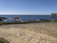 a sign posted at the edge of a stone sidewalk pointing out into the ocean, and another sign indicating no parking, which is right for us