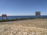 a sign posted at the edge of a stone sidewalk pointing out into the ocean, and another sign indicating no parking, which is right for us