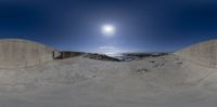 this photo features a wide angle lens of the sky showing a sunny day and some blue skies above a sandy beach