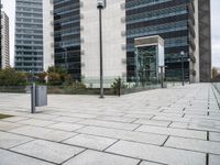 there is a street light by a sidewalk next to tall buildings and grass in front of them