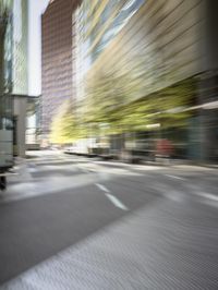 a man with a black shirt riding a green motorcycle in the city street through a blurry picture