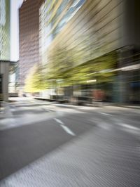 a man with a black shirt riding a green motorcycle in the city street through a blurry picture