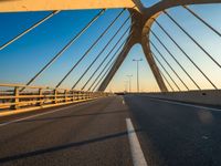 a long bridge that is over a river with water in the background and a yellow line