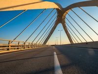 a long bridge that is over a river with water in the background and a yellow line