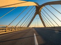 a long bridge that is over a river with water in the background and a yellow line