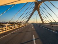 a long bridge that is over a river with water in the background and a yellow line