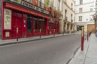 two people on a street with no cars on it in front of a bar with a sign that says private rue de france