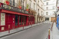 two people on a street with no cars on it in front of a bar with a sign that says private rue de france