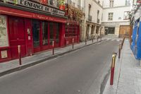 two people on a street with no cars on it in front of a bar with a sign that says private rue de france