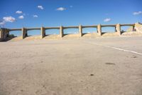 there is a dirt field with concrete walls on it and a concrete walkway above the concrete wall