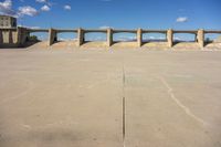 there is a dirt field with concrete walls on it and a concrete walkway above the concrete wall