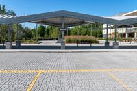 parking lot with empty parking spaces under a canopy over a street area at a city