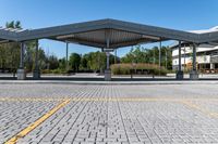 parking lot with empty parking spaces under a canopy over a street area at a city