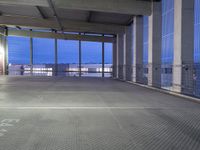 the view of a parking garage through a large glass door at night on a rooftop