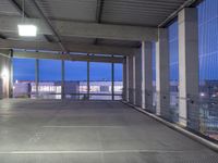 the view of a parking garage through a large glass door at night on a rooftop