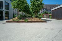 a large concrete courtyard with a brick planter on the bottom and trees in it