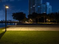 a view of a grassy area with a building in the background at night in miami