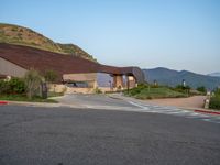 a building that has a bunch of windows on it at sunset with mountains in the background