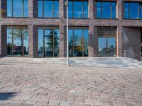 the large building is made of concrete and has metal railings around it, which are made of brick