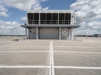 a view of an empty parking lot next to an airport terminal with white lines on the tarmac