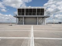 a view of an empty parking lot next to an airport terminal with white lines on the tarmac