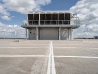 a view of an empty parking lot next to an airport terminal with white lines on the tarmac