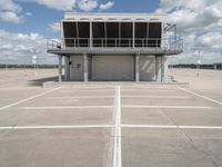 a view of an empty parking lot next to an airport terminal with white lines on the tarmac