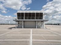 a view of an empty parking lot next to an airport terminal with white lines on the tarmac