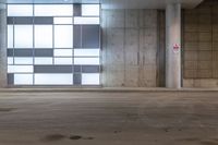 an empty parking garage with a few lights on the side of the building, with no people in