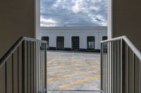 a gate with the doorway open showing a building and a cloudy sky in the background