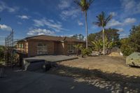 a house that has been partially under construction with some trees on the other side of the driveway