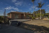 a house that has been partially under construction with some trees on the other side of the driveway