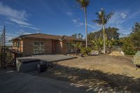 a house that has been partially under construction with some trees on the other side of the driveway