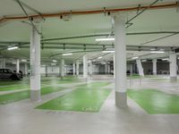 an empty parking garage with parking lights on the ceiling and green floor area on the floors