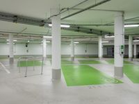 an empty parking garage with parking lights on the ceiling and green floor area on the floors