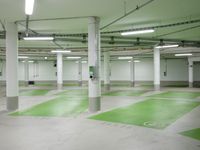 an empty parking garage with parking lights on the ceiling and green floor area on the floors