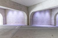 an empty parking lot with lights on each side and columns on the other side of the room