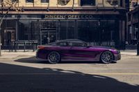 a shiny purple sports car parked in front of a coffee co restaurant on a city street