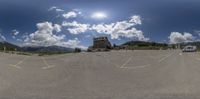 this is the view in fish - eye lens of an empty parking lot, with trucks parked in front of it