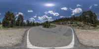 a 3d image of a road from a fish eye lens of an area with very rocks and sand in the foreground