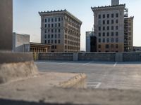 several large empty parking spaces in the city with buildings nearby in front of them -