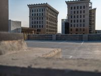 several large empty parking spaces in the city with buildings nearby in front of them -