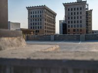 several large empty parking spaces in the city with buildings nearby in front of them -