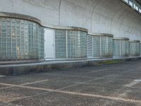 two empty parking spaces with two empty doors and a large window on the wall between two buildings