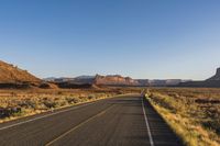 the highway through the desert is quiet and empty of traffic during the day light or setting
